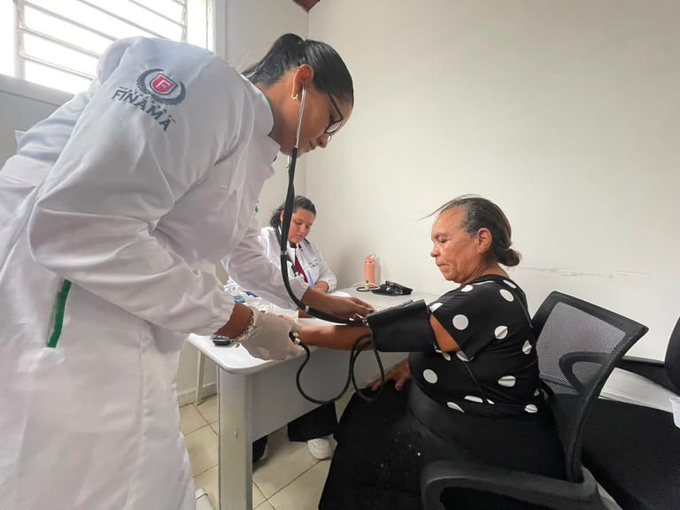 Profissional verifica a pressão arterial de uma mulher durante uma ação de saúde